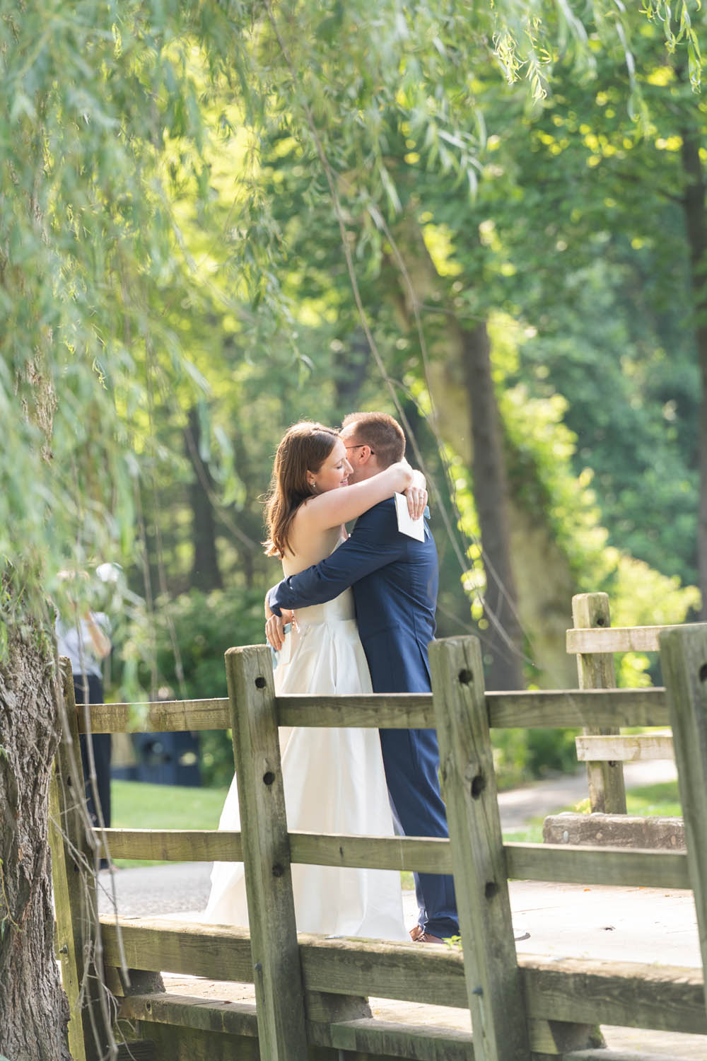 Bride and Groom Embrace on Bridge at Hollow Brook Golf Club Wedding