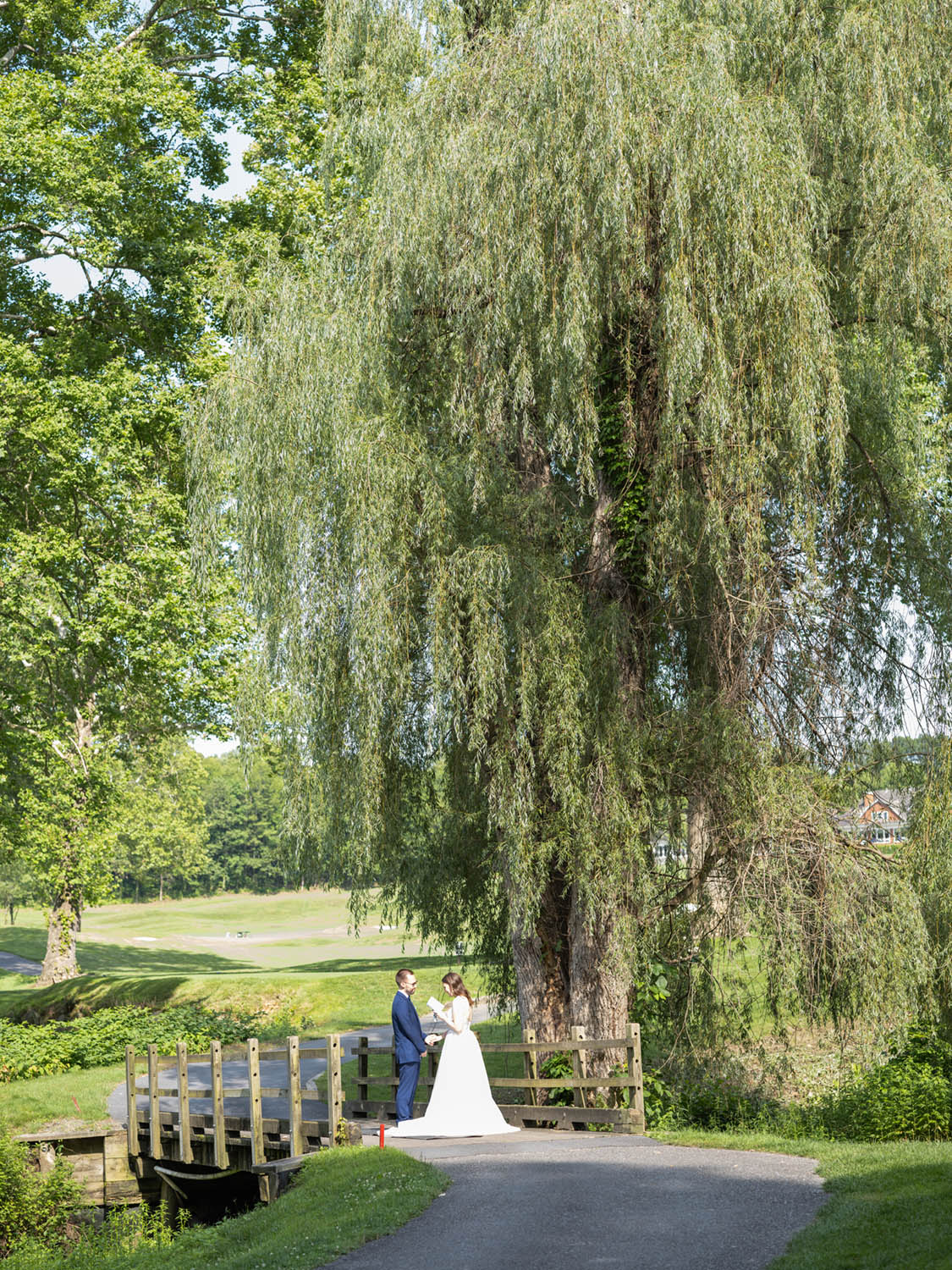 Bride and Groom Exchange Notes on Bridge at Hollow Brook Golf Club