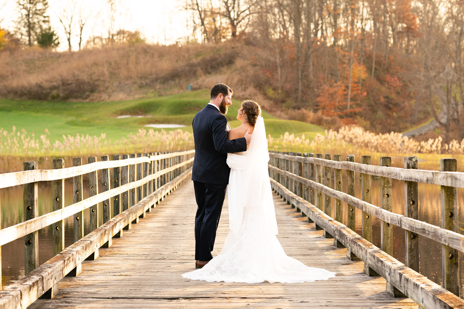 A newly married couple standing on a wooden bridge at Hollow Brook Golf Club in Cortlandt Manor, NY