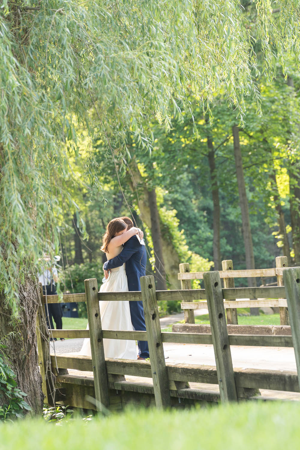 Bride and Groom Embrace on Bridge at Hollow Brook Golf Club Wedding