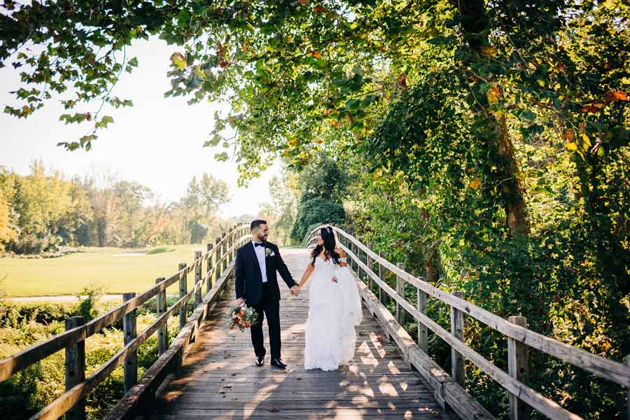 Couple having a photography session at a scenic view of a bridge at Hollow Brook Golf Club