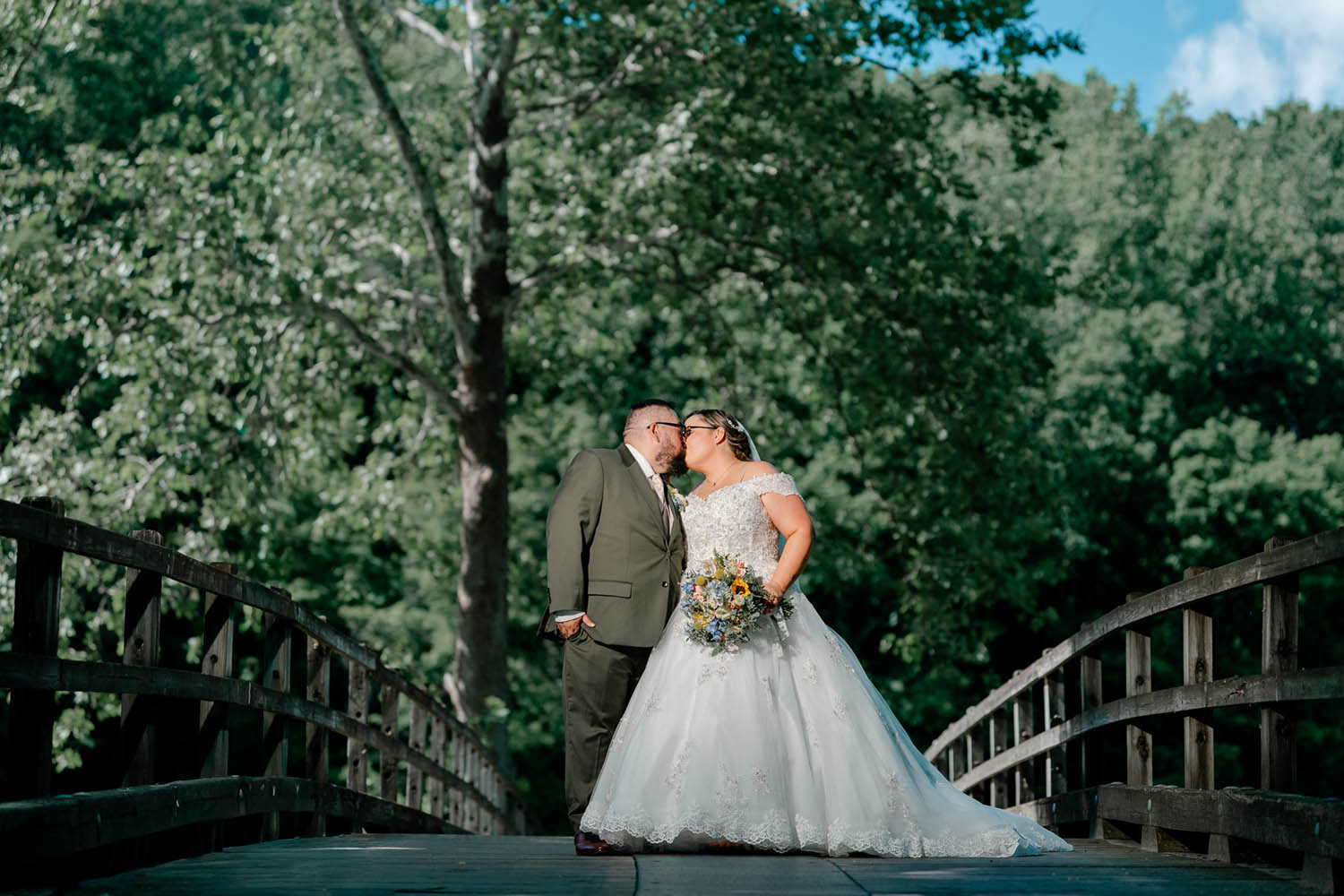 Bride and Groom Kiss at a Hollow Brook Golf Course Bridge