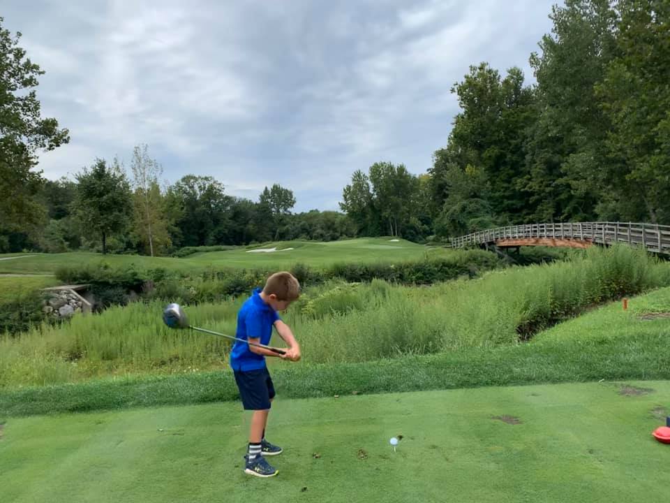 A young boy teeing off during a sunny day at Hollow Brook Golf Club in Cortlandt Manor, NY