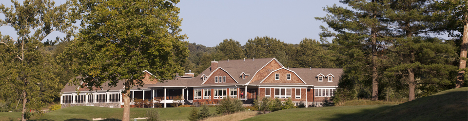 Scenic exterior view of Hollow Brook Golf Club clubhouse surrounded by trees and greenery in Cortlan