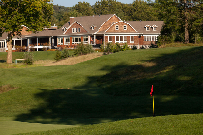 Scenic exterior view of Hollow Brook Golf Club clubhouse surrounded by trees and greenery in Cortlan